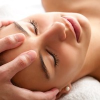 44647496 - close up head shot  of woman having curative facial massage. therapist applying pressure with thumbs on forehead.